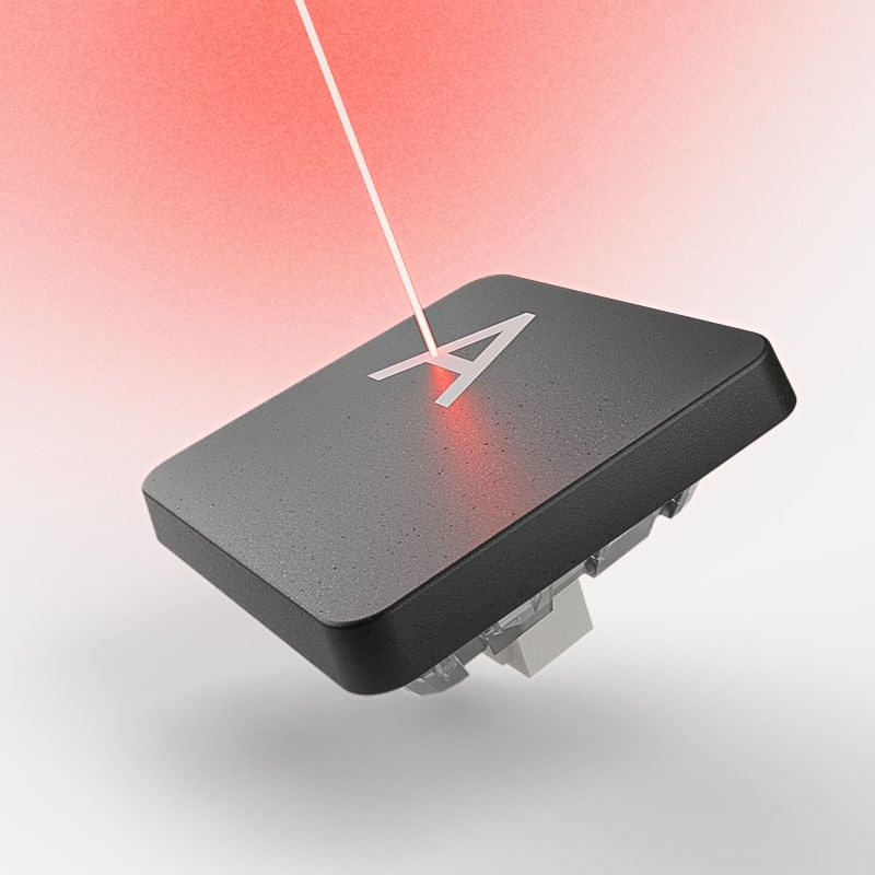 Mouse ergonômico ao lado de um notebook.